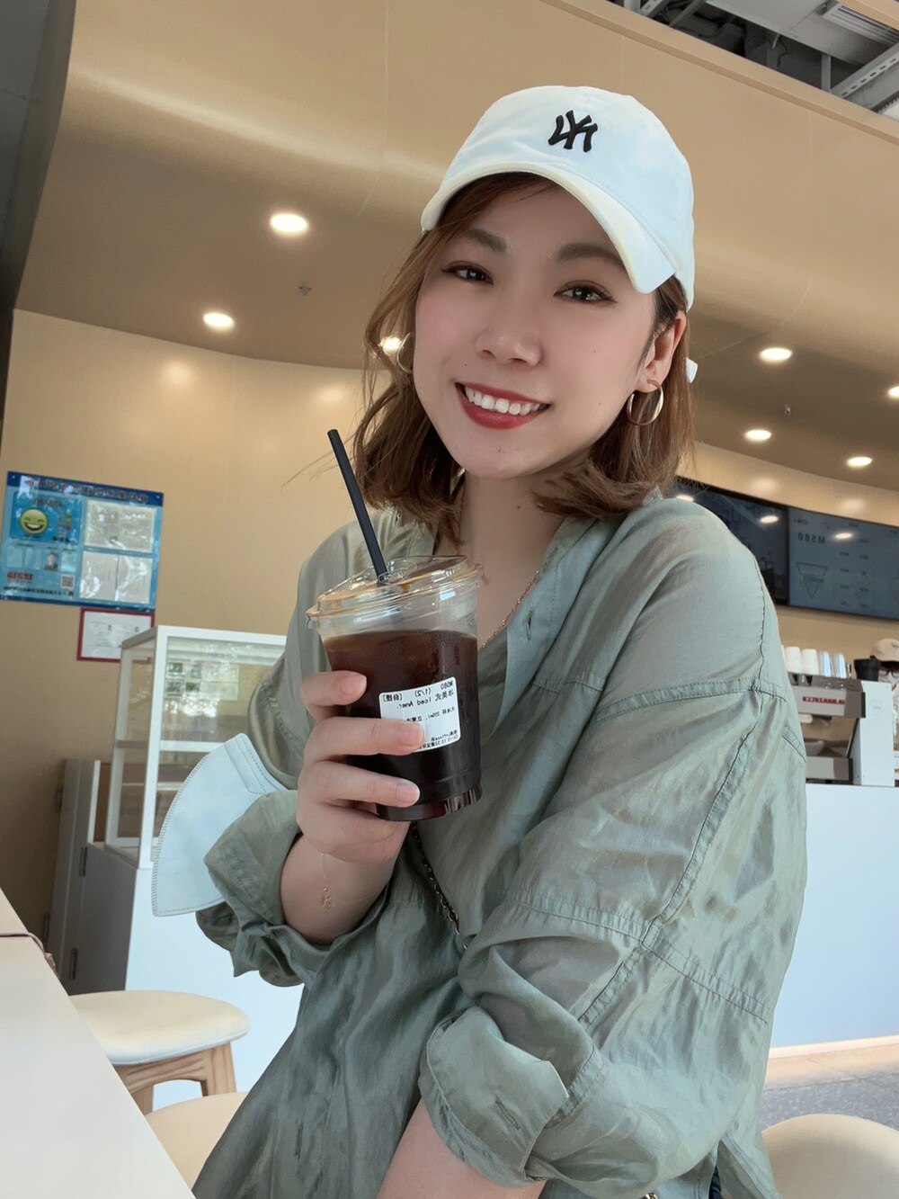 ホワイト系のキャップを着用したレディースの夏コーディネートの2枚目の写真