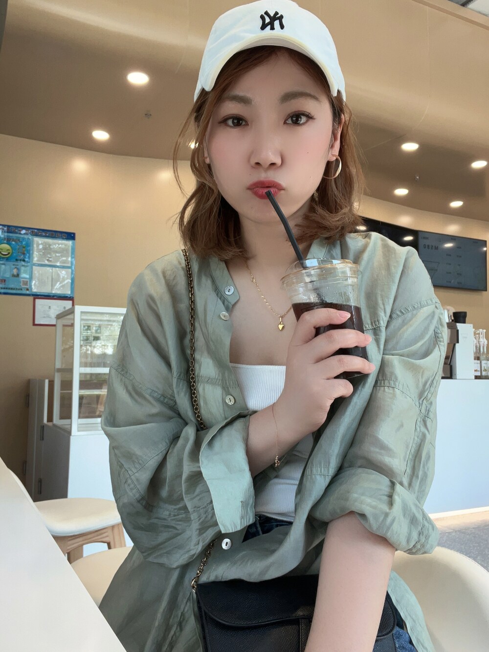 ホワイト系のキャップを着用したレディースの夏コーディネートの3枚目の写真