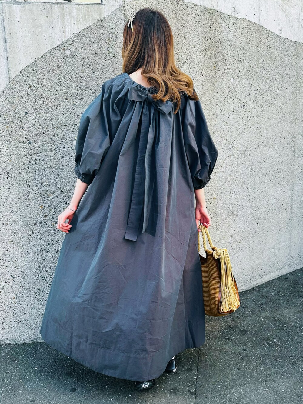 グレー系のワンピース、ベージュ系のトートバッグ、グレー系のバレエシューズを着用したレディースの春コーディネートの3枚目の写真