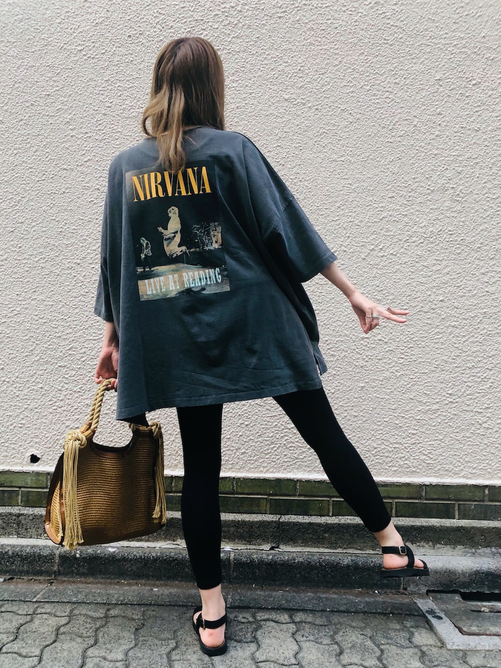 ブラック系のTシャツ/カットソー、ベージュ系のトートバッグ、ブラック系のサンダルを着用したレディースの夏コーディネートの2枚目の写真