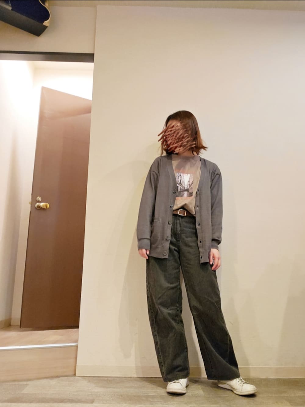 ブラック系のデニムパンツ、ブラウン系のTシャツ/カットソー、グレー系のカーディガン/ボレロを着用したレディースの春コーディネートの2枚目の写真