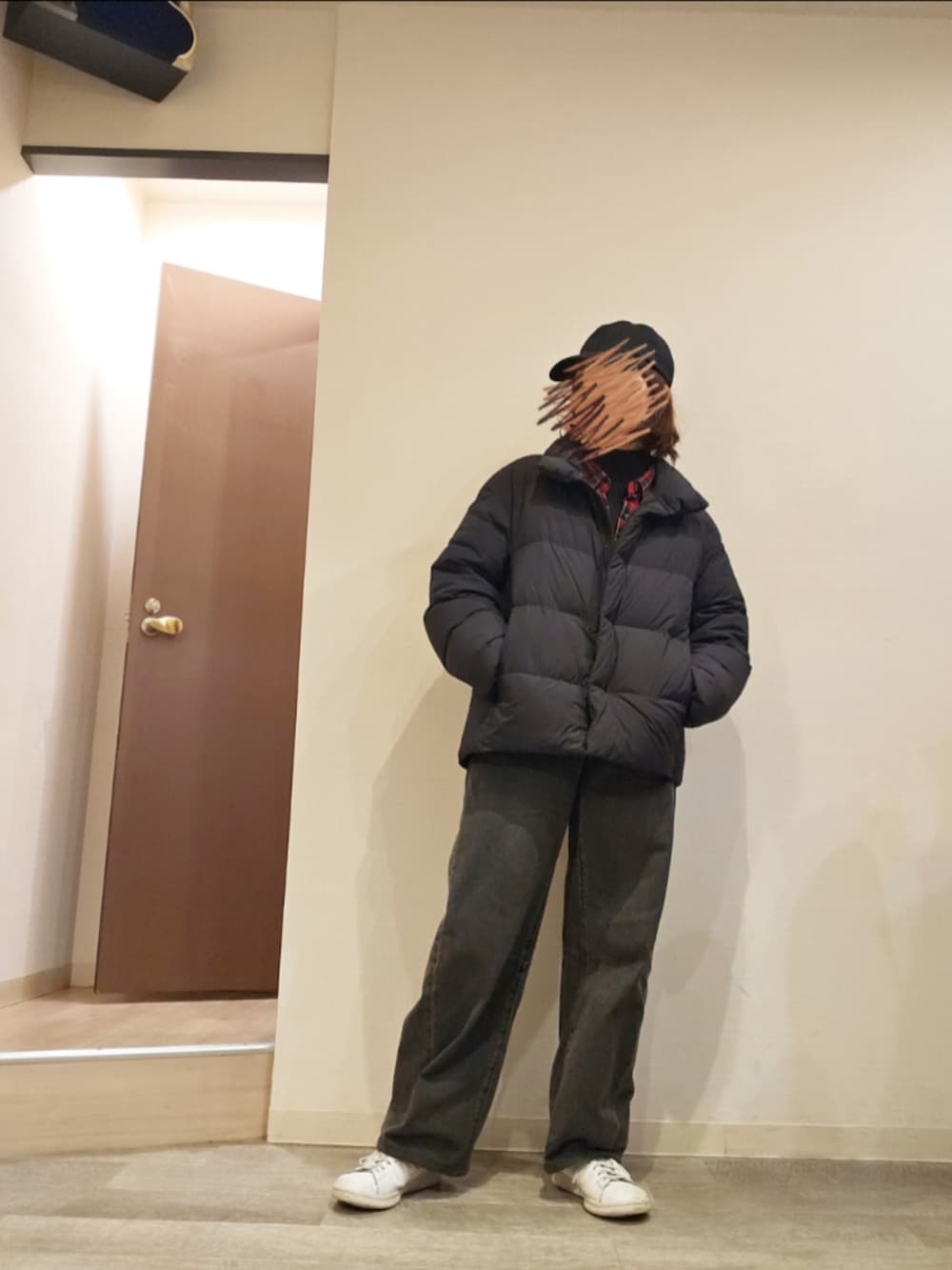 ブラック系のデニムパンツ、ブラック系のニット/セーター、レッド系のシャツ/ブラウスを着用したレディースの冬コーディネートの2枚目の写真