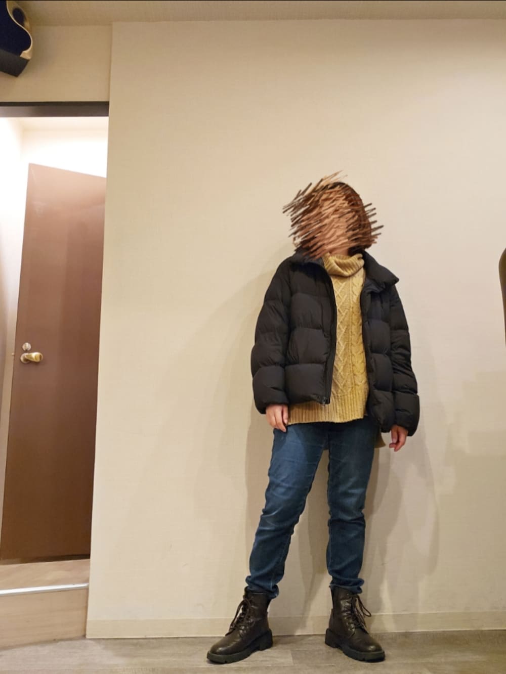 ブルー系のデニムパンツ、ベージュ系のニット/セーター、ブラウン系のブーツを着用したレディースの冬コーディネートの2枚目の写真