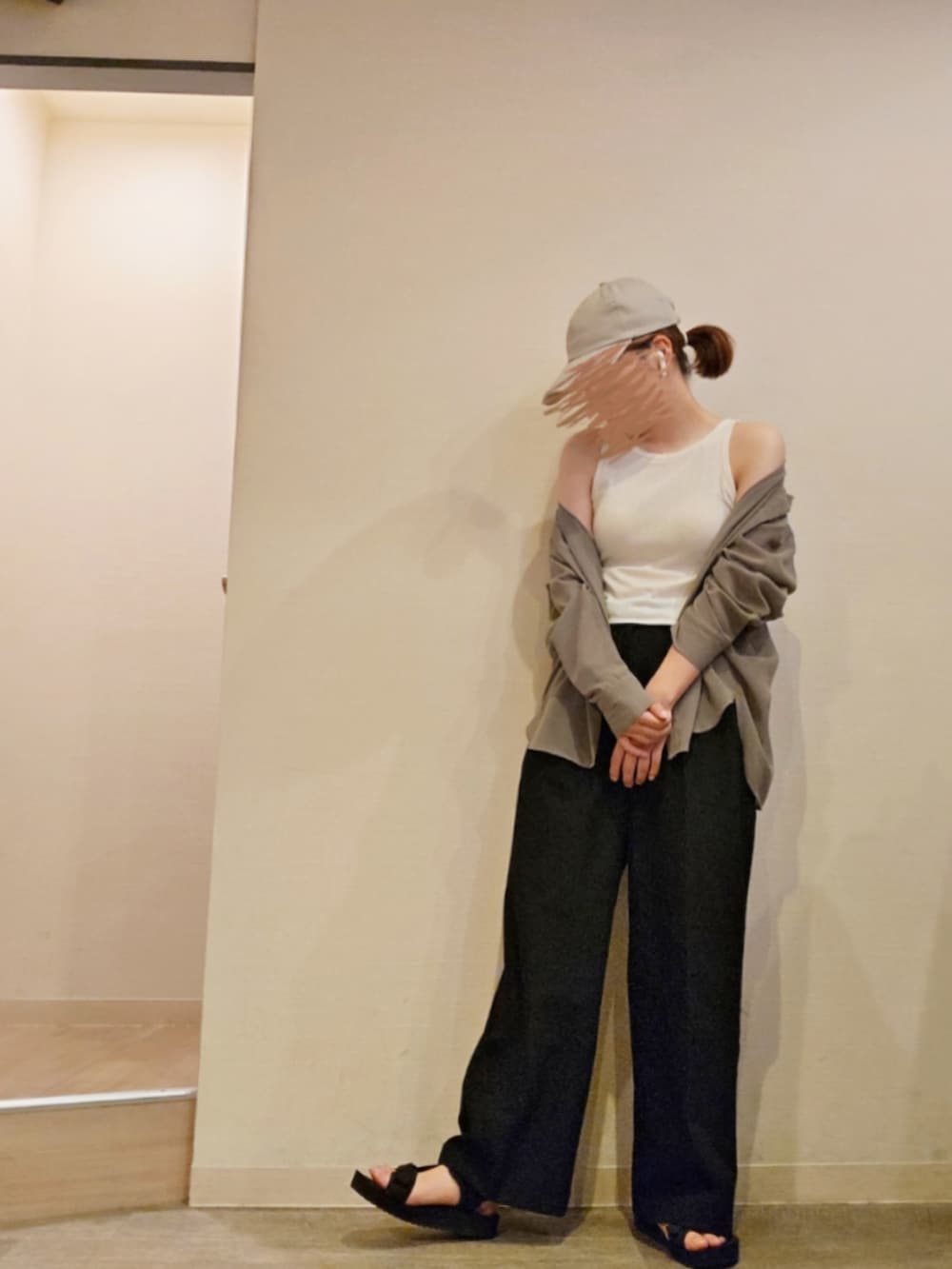 ブラック系のスラックス、グリーン系のシャツ/ブラウス、ホワイト系のタンクトップを着用したレディースの夏コーディネートの2枚目の写真