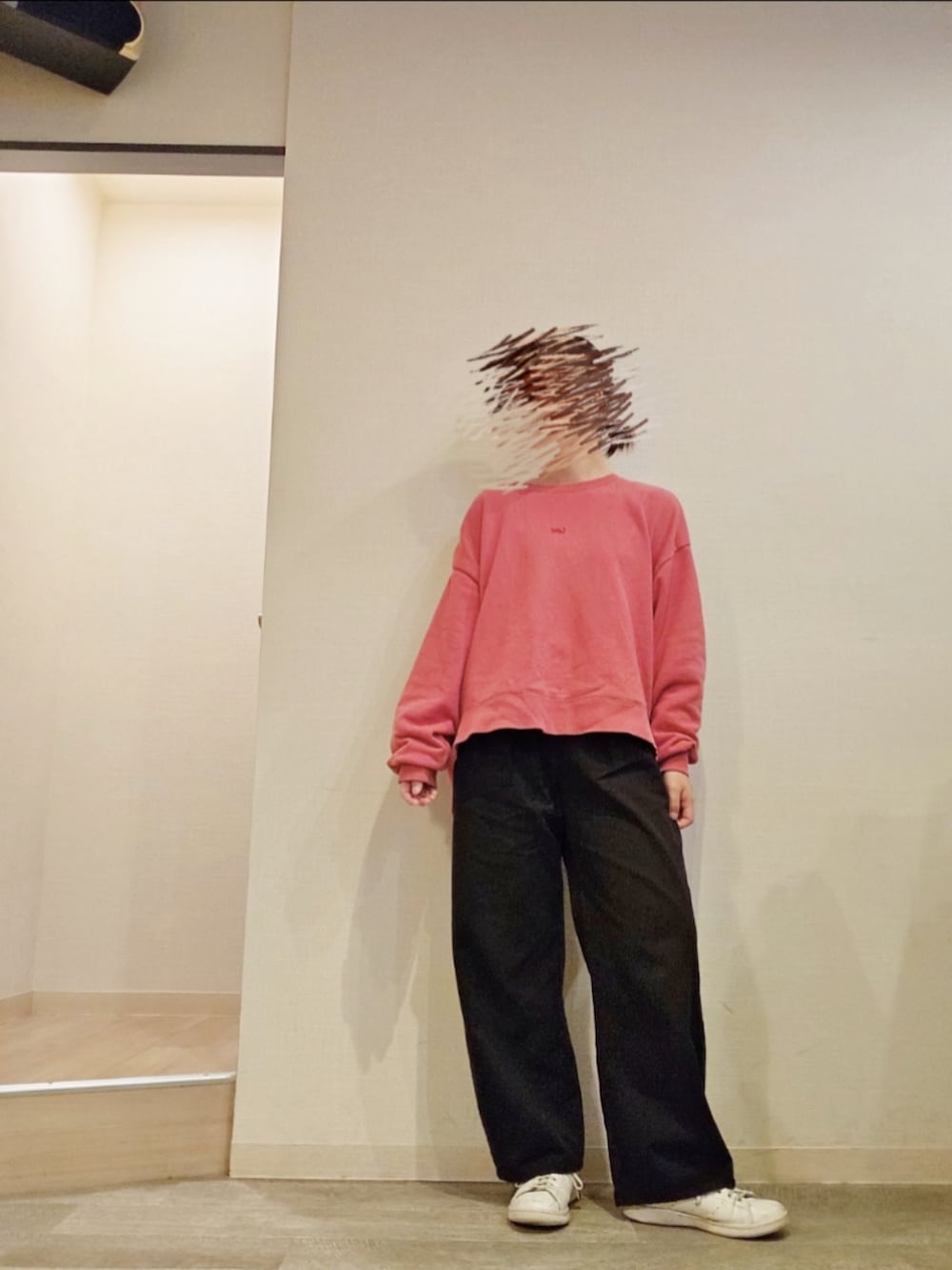 ブラック系のチノパンツ、ピンク系のスウェットを着用したレディースの秋コーディネートの2枚目の写真