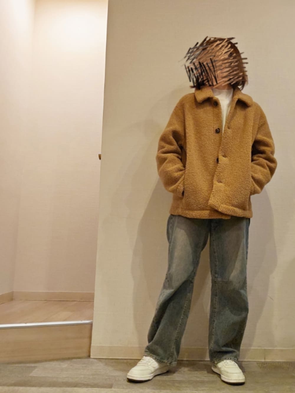 ブルー系のデニムパンツ、ホワイト系のニット/セーター、ベージュ系のジャケット/アウターを着用したレディースの冬コーディネートの2枚目の写真