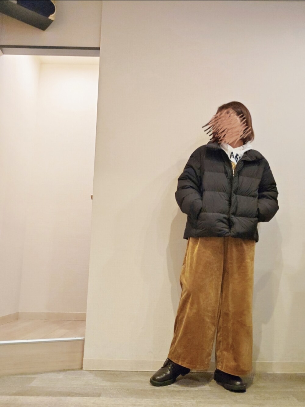 ホワイト系のパーカー、イエロー系のパンツ、ブラウン系のブーツを着用したレディースの冬コーディネートの2枚目の写真