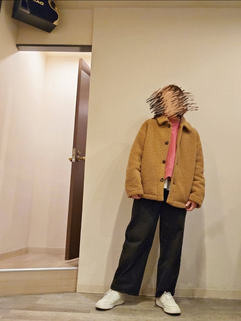 ブラック系のチノパンツ、ピンク系のスウェット、ホワイト系のTシャツ/カットソーを着用したレディースの冬コーディネートの2枚目の写真