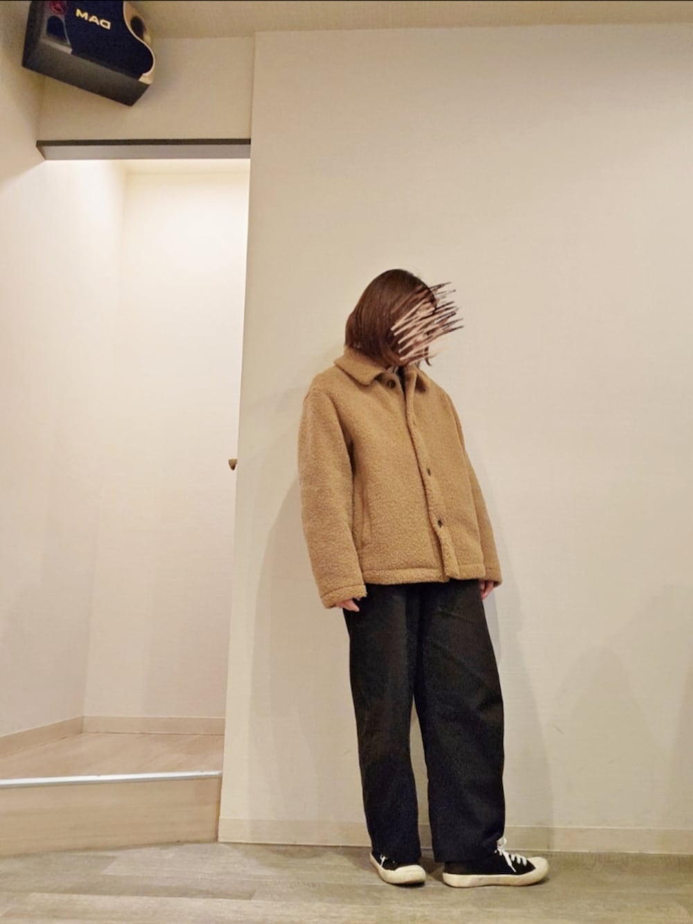 ブラック系のチノパンツ、ブルー系のニット/セーター、ホワイト系のシャツ/ブラウスを着用したレディースの秋コーディネートの3枚目の写真