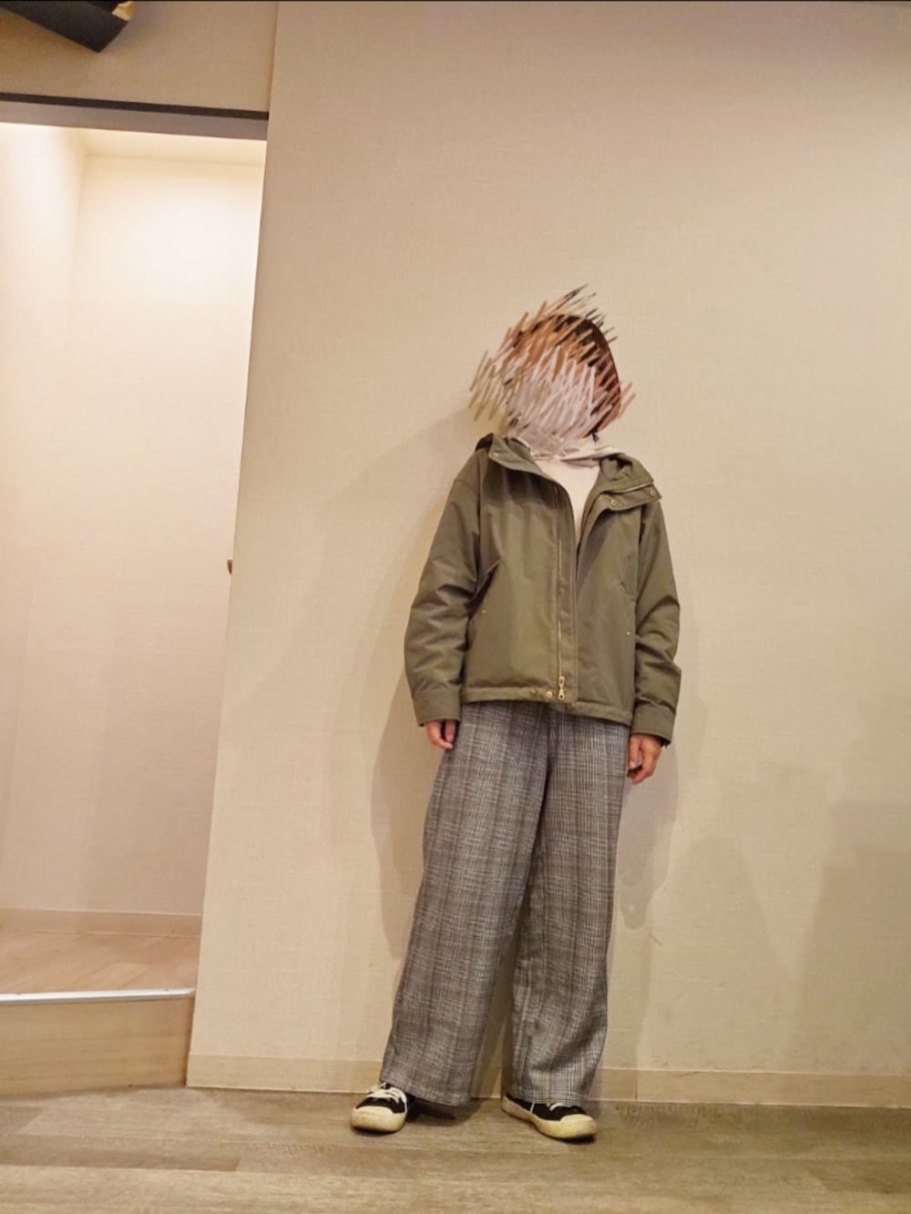 ベージュ系のパーカー、ホワイト系のTシャツ/カットソー、グレー系のスラックスを着用したレディースの秋コーディネートの2枚目の写真