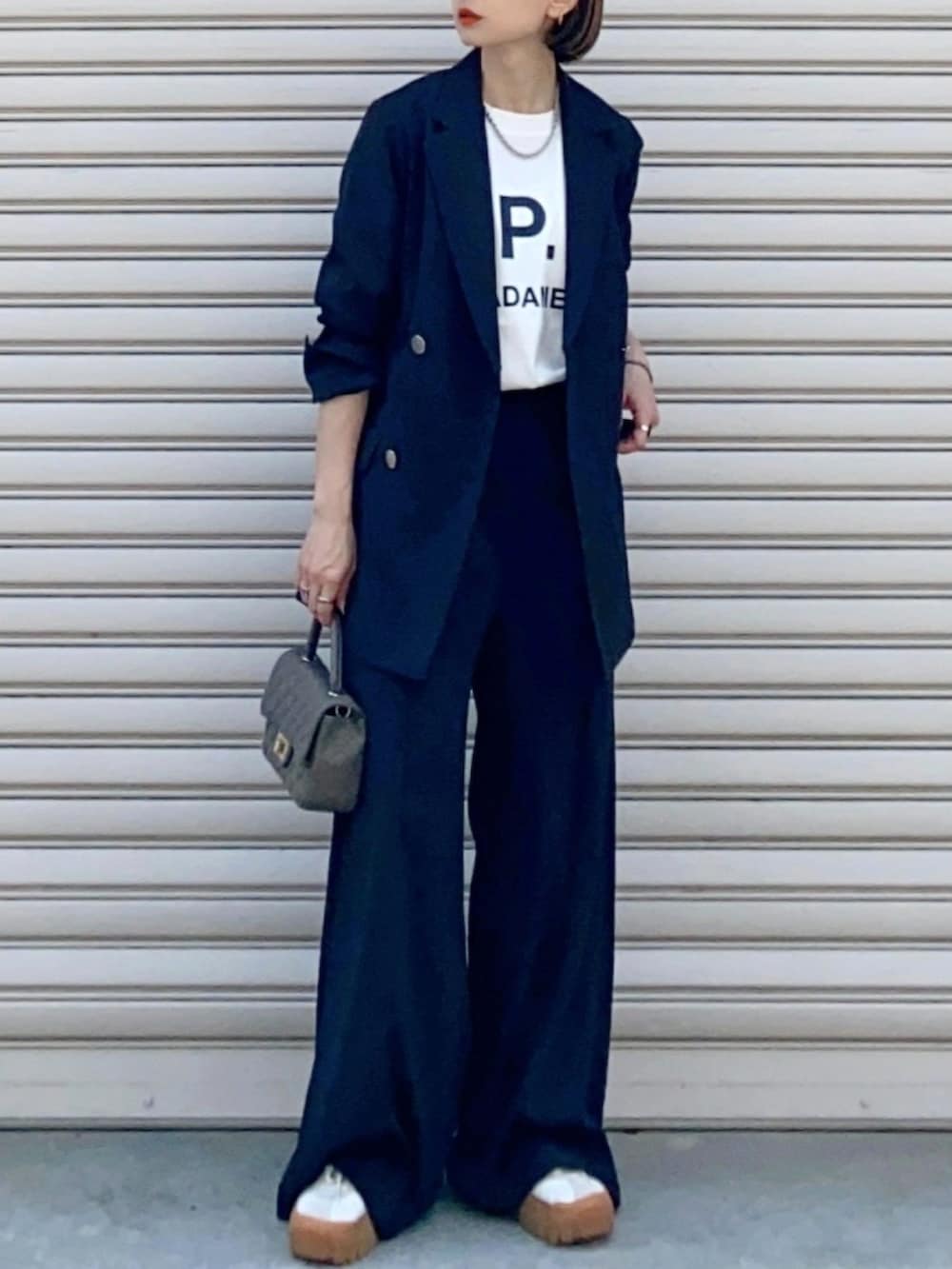 ブラック系のテーラードジャケット、ホワイト系のTシャツ/カットソー、ブラック系のその他パンツを着用したレディースの春コーディネートの2枚目の写真