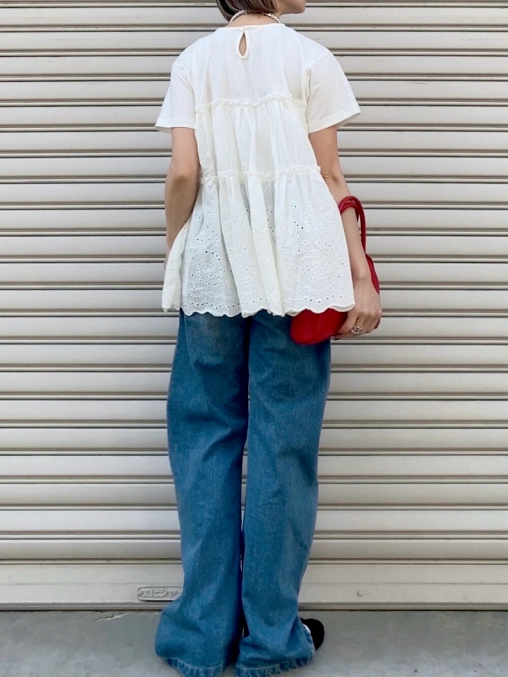 ホワイト系のTシャツ/カットソー、ブルー系のデニムパンツ、ブラック系のバレエシューズを着用したレディースの春コーディネートの2枚目の写真