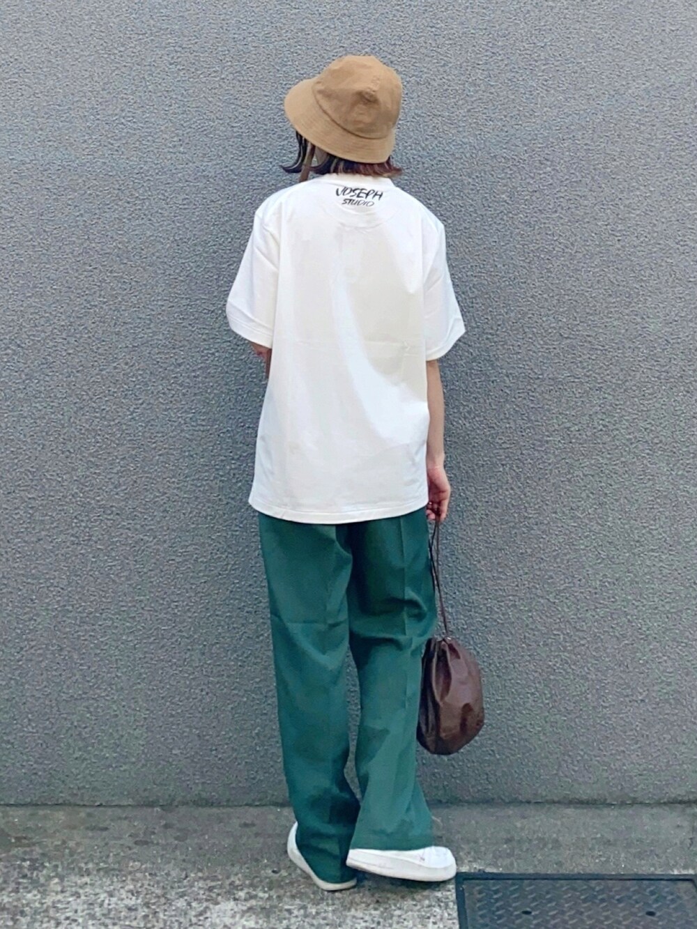 ホワイト系のTシャツ/カットソー、ホワイト系のスニーカー、グリーン系のスラックスを着用したレディースの春コーディネートの2枚目の写真