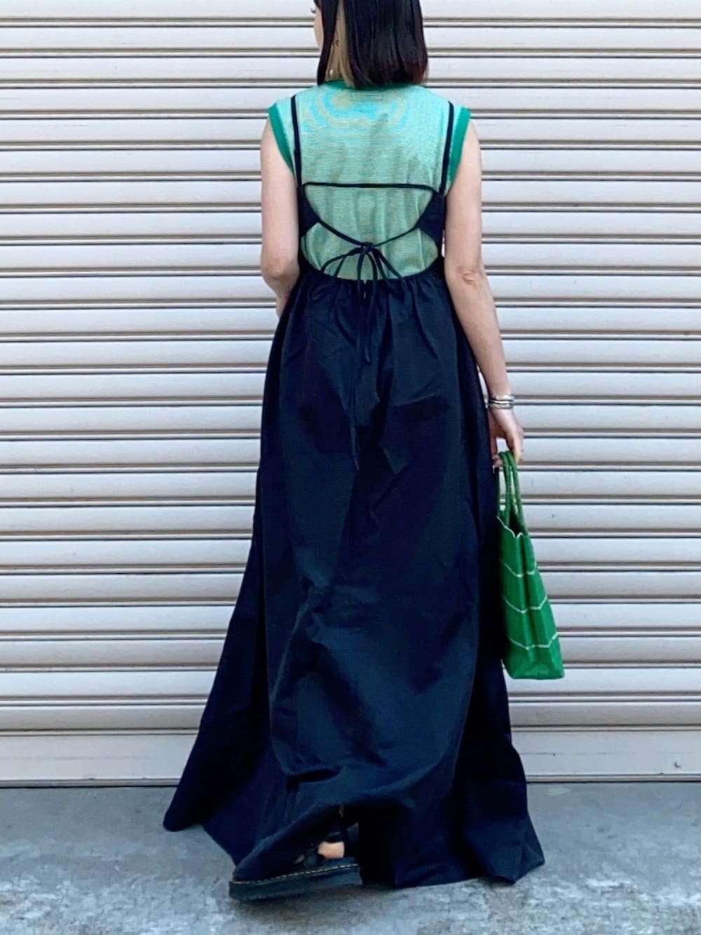 ブラック系のワンピース、グリーン系のハンドバッグ、グリーン系のTシャツ/カットソーを着用したレディースの春コーディネートの2枚目の写真