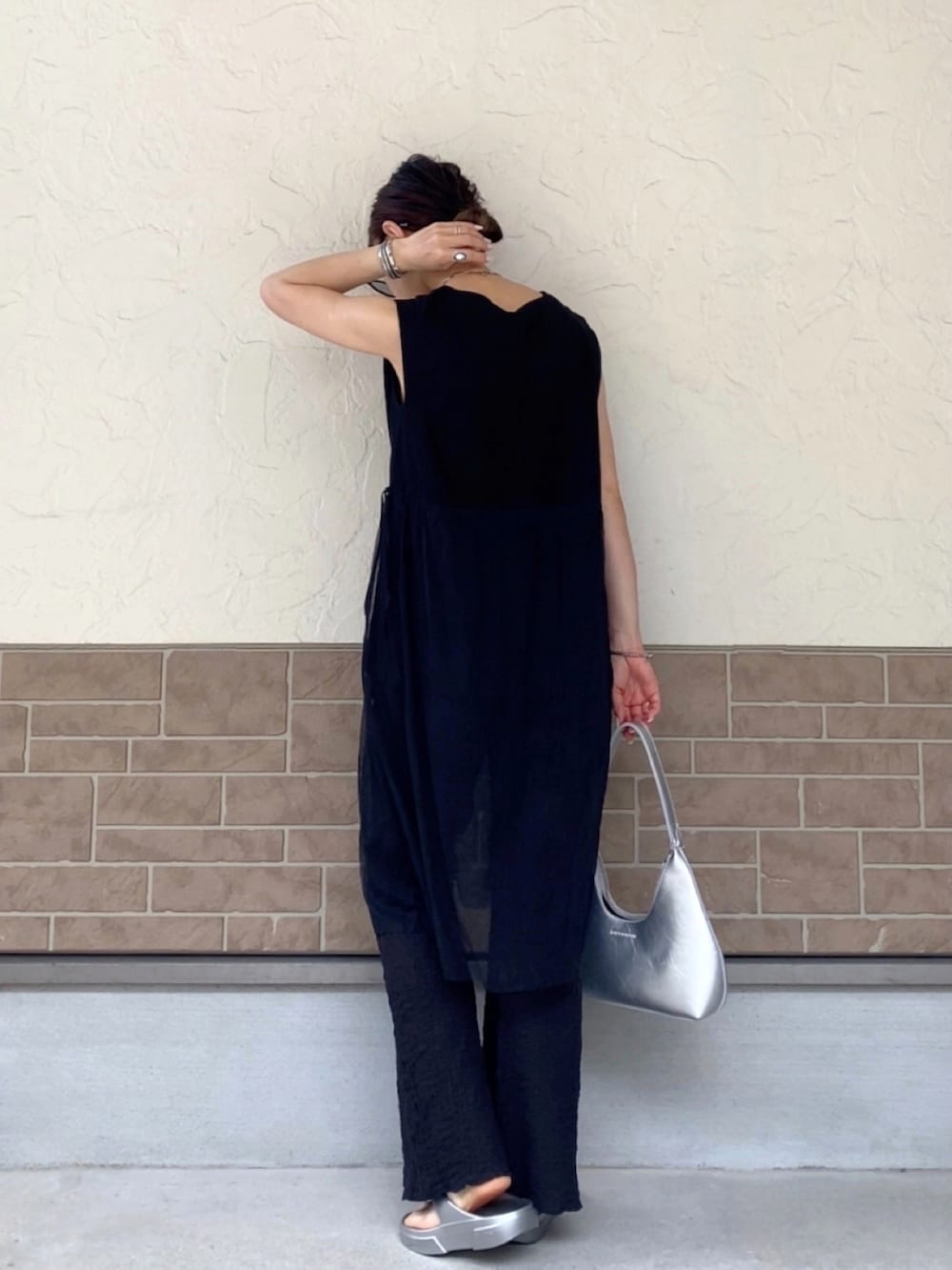 ブラック系のTシャツ/カットソー、ブラック系のその他パンツ、シルバー系のサンダルを着用したレディースの春コーディネートの2枚目の写真