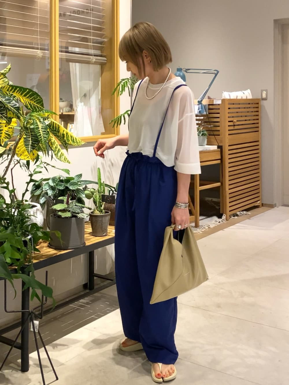 ベージュ系のハンドバッグ、ホワイト系のTシャツ/カットソー、ブルー系のその他パンツを着用したレディースの春コーディネートの2枚目の写真