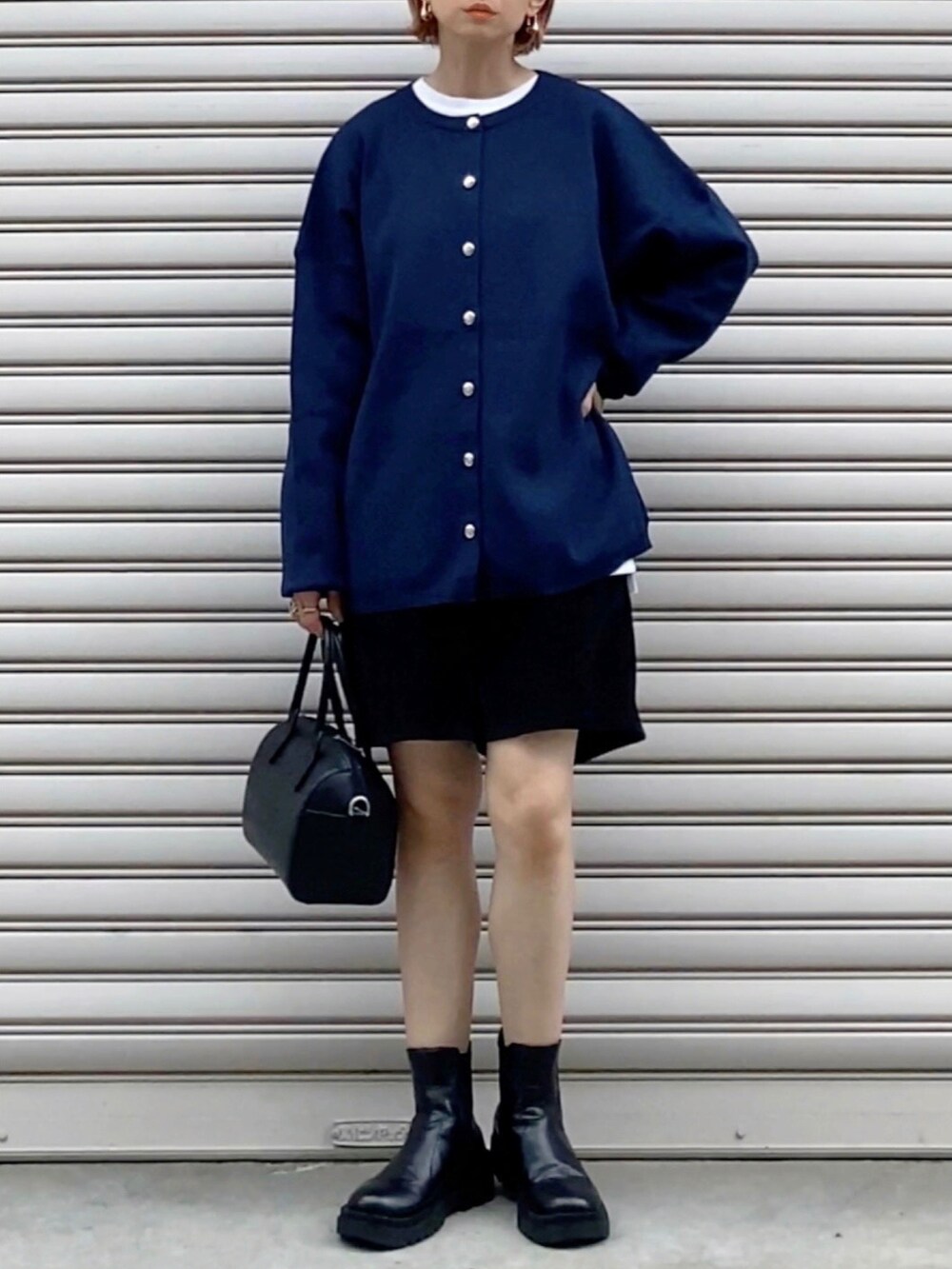 ブラック系のボストンバッグ、ブラック系のブーツ、ブラック系のパンツを着用したレディースの秋コーディネートの2枚目の写真