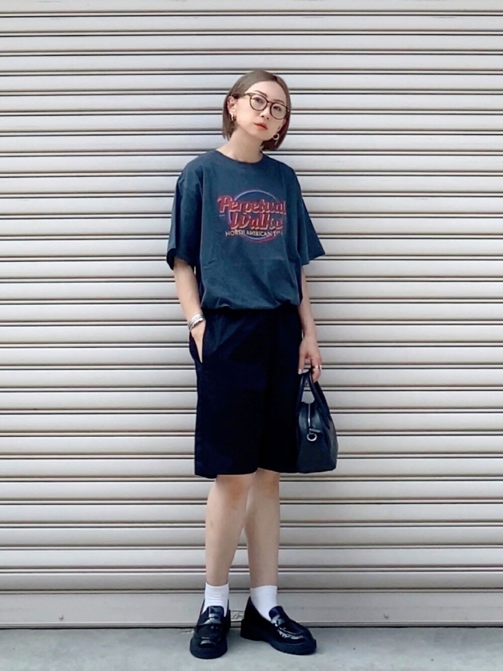 グレー系のTシャツ/カットソー、ブラック系のチノパンツ、ブラック系のローファーを着用したレディースの夏コーディネートの3枚目の写真
