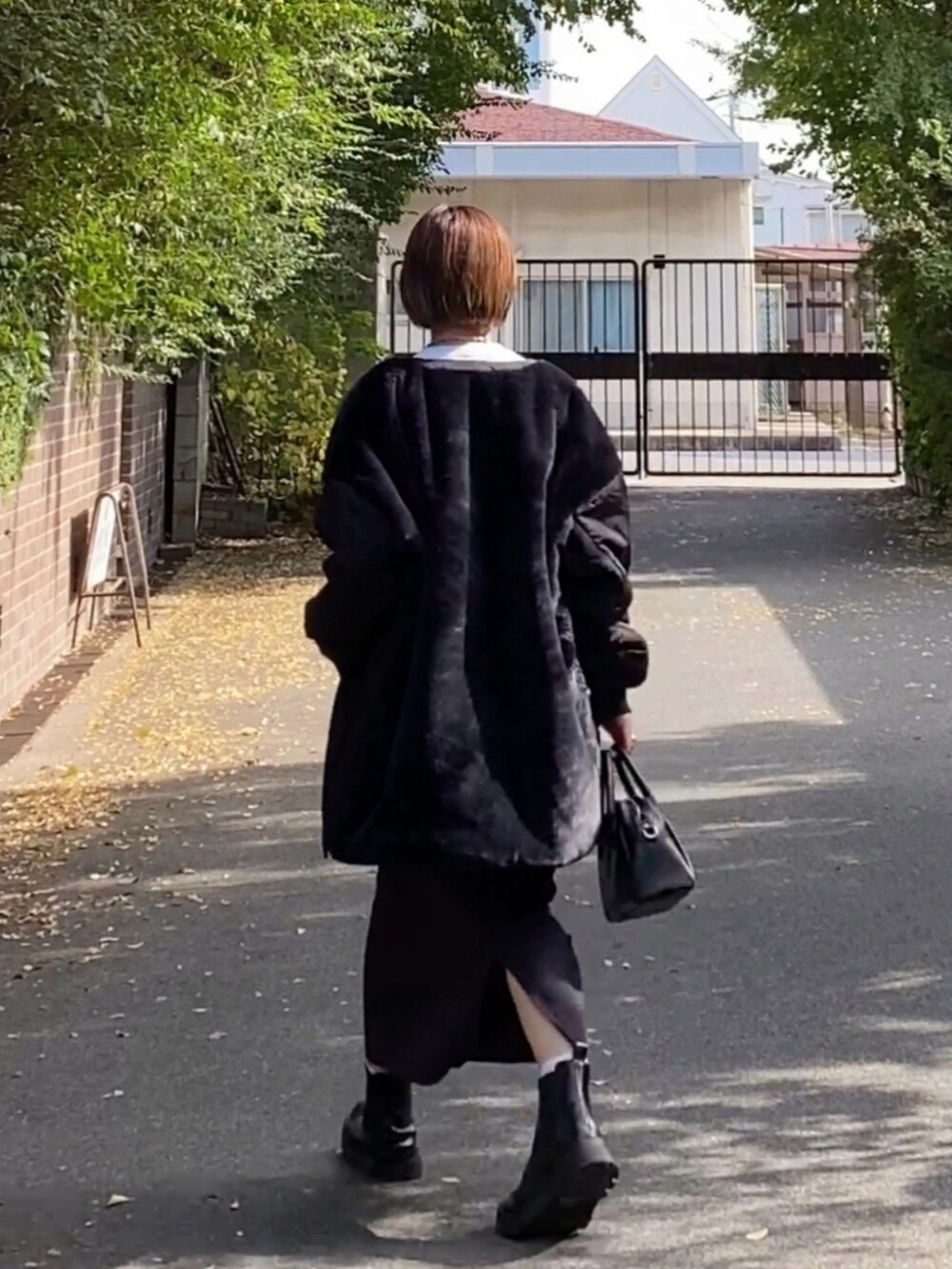 ホワイト系のTシャツ/カットソー、ブラック系のジャケット/アウター、グレー系のスカートを着用したレディースの秋コーディネートの2枚目の写真