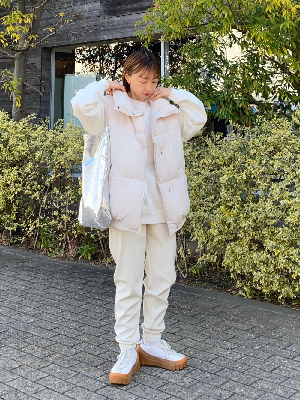 ホワイト系のスウェット、ホワイト系のジャケット/アウター、シルバー系のトートバッグを着用したレディースの冬コーディネートの2枚目の写真