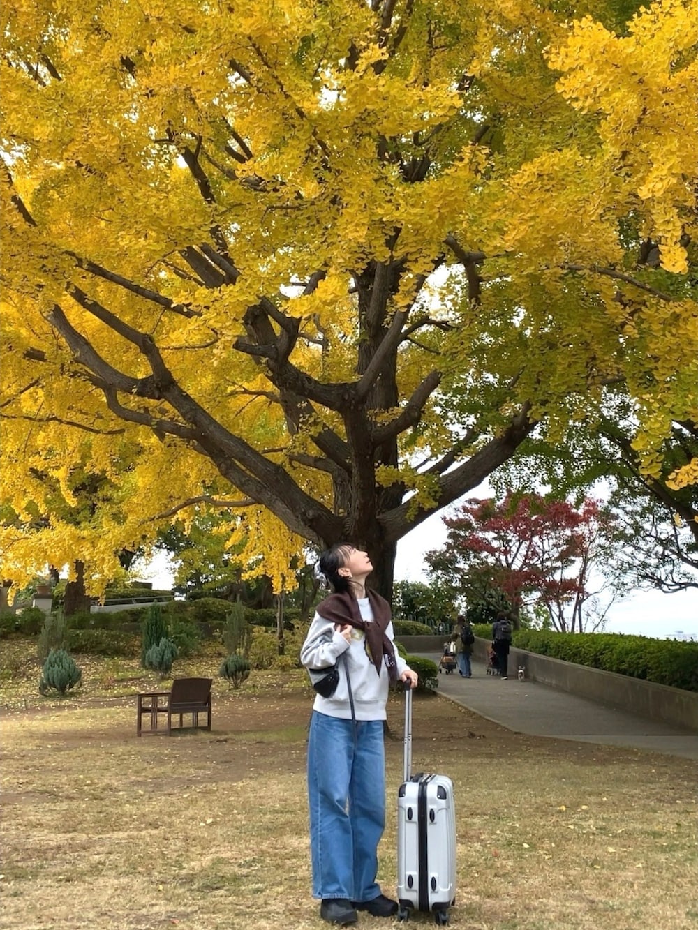 ブルー系のデニムパンツ、グレー系のスウェット、ブラック系のショルダーバッグを着用したレディースの冬コーディネートの3枚目の写真