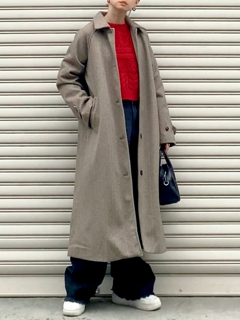 レッド系のニット/セーター、ブラウン系のステンカラーコート、ブラック系のボストンバッグを着用したレディースの冬コーディネートの2枚目の写真