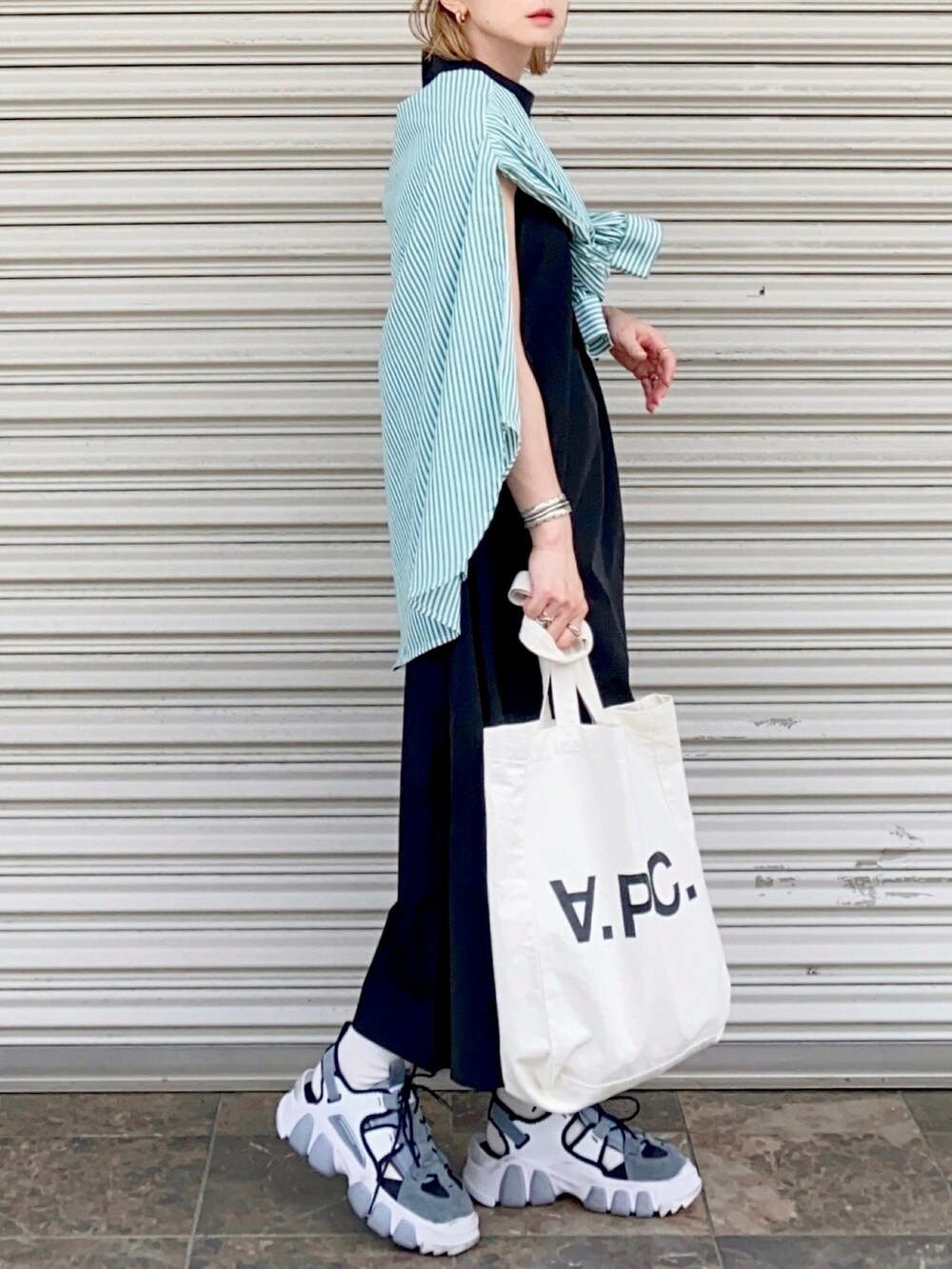 ホワイト系のトートバッグ、グリーン系のシャツ/ブラウス、ブラック系のワンピースを着用したレディースの春コーディネートの3枚目の写真