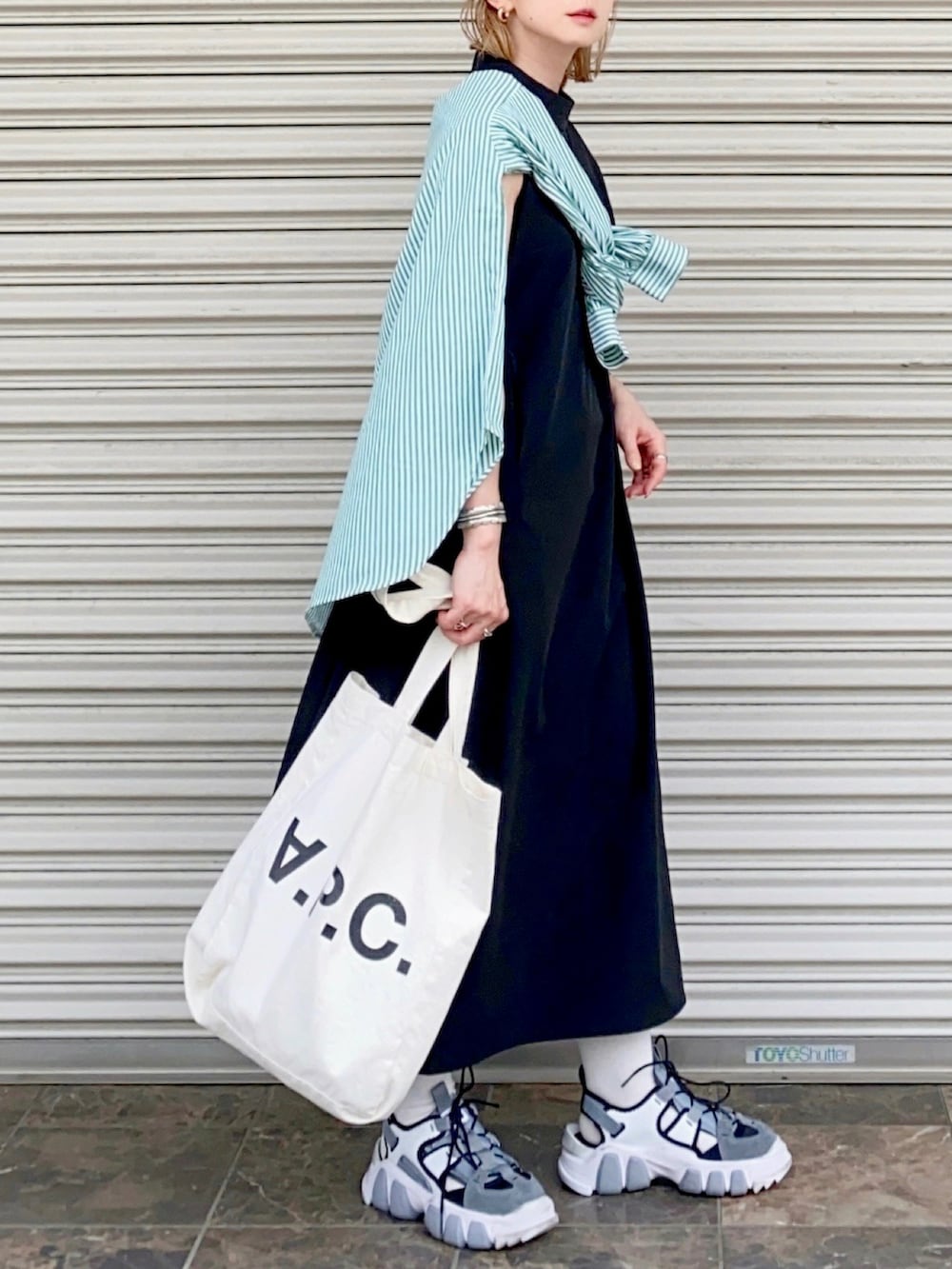 ホワイト系のトートバッグ、グリーン系のシャツ/ブラウス、ブラック系のワンピースを着用したレディースの春コーディネートの2枚目の写真