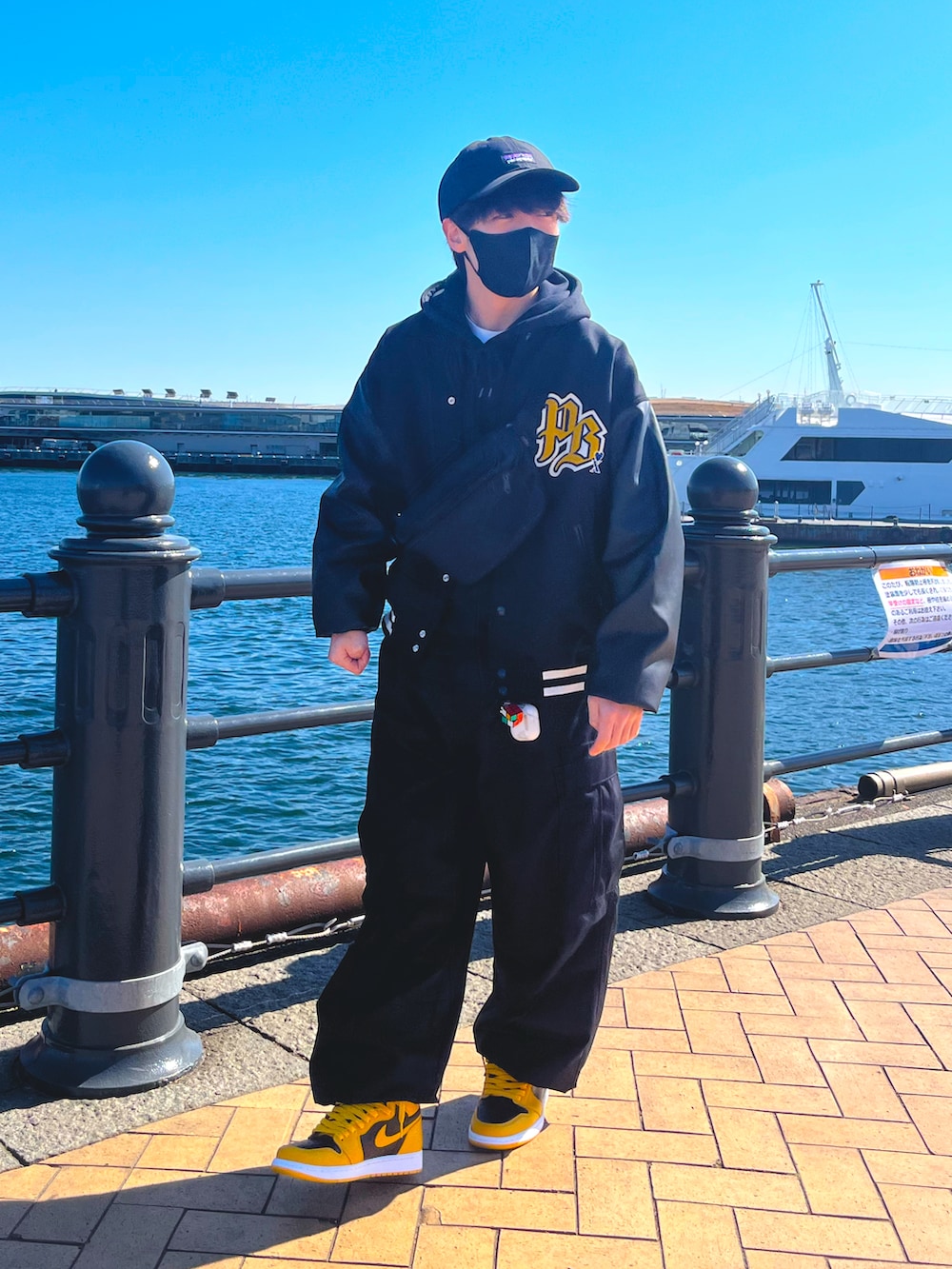 ブラック系のスタジャン、ブラック系のカーゴパンツ、イエロー系のスニーカーを着用したメンズの冬コーディネートの2枚目の写真