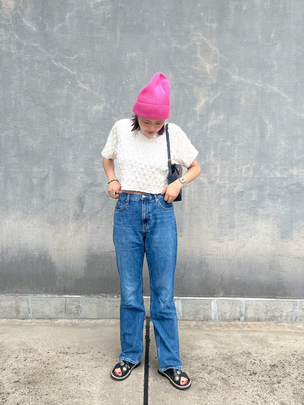 ホワイト系のTシャツ/カットソー、ブルー系のデニムパンツ、ブラック系のバッグを着用したレディースの夏コーディネートの2枚目の写真