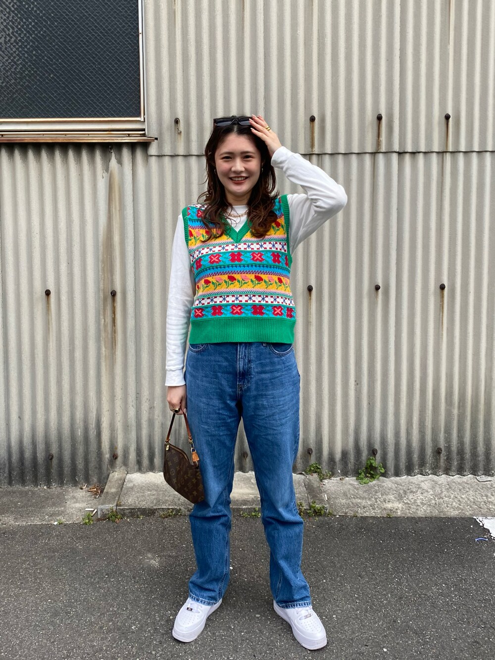 グリーン系のベスト、ベージュ系のブルゾン、ブルー系のデニムパンツを着用したレディースの冬コーディネートの2枚目の写真