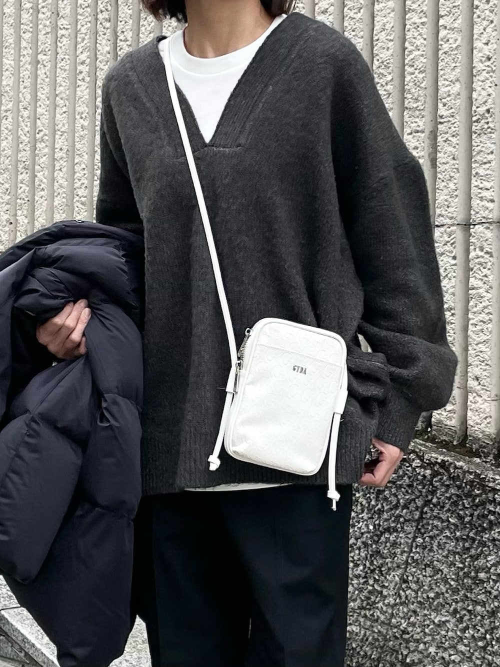 ホワイト系のショルダーバッグを着用したレディースの冬コーディネートの2枚目の写真