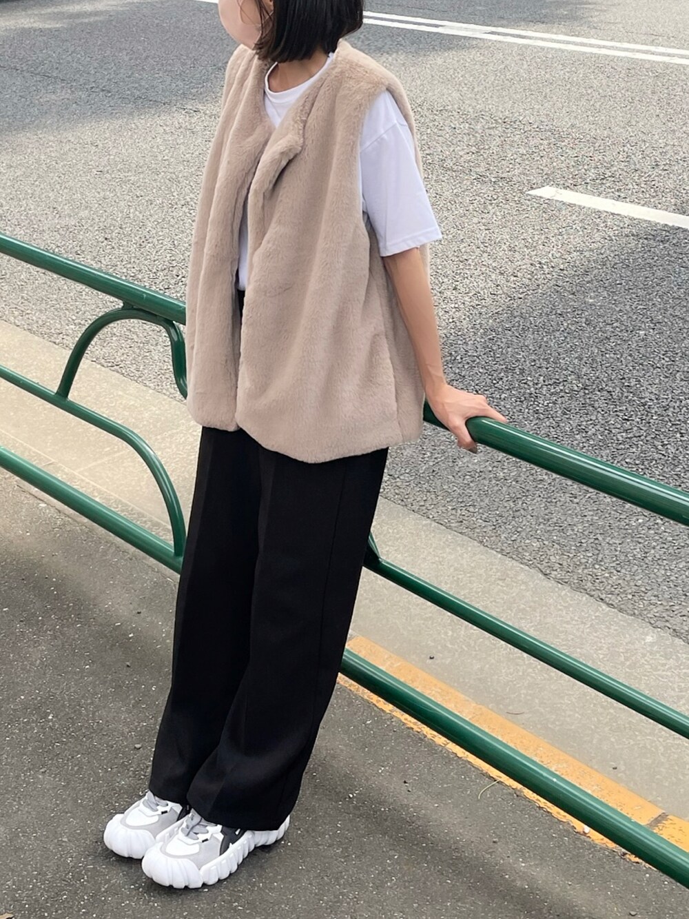 ホワイト系のTシャツ/カットソー、ブラウン系のベスト、ブラック系のスラックスを着用したレディースの秋コーディネートの2枚目の写真