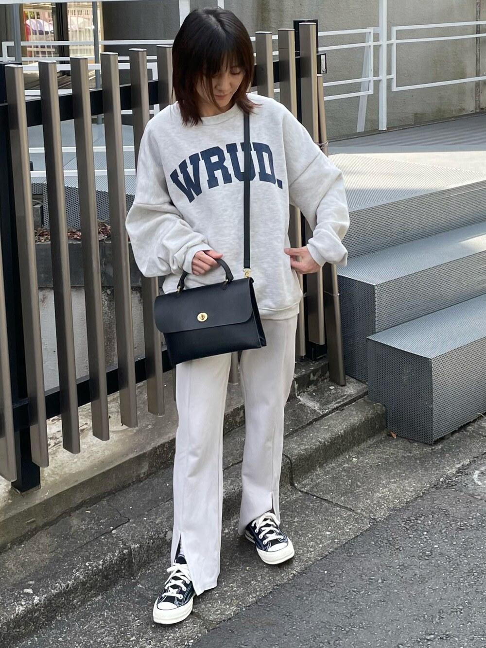グレー系のスウェット、ホワイト系のその他パンツ、ブラック系のショルダーバッグを着用したレディースの春コーディネートの2枚目の写真
