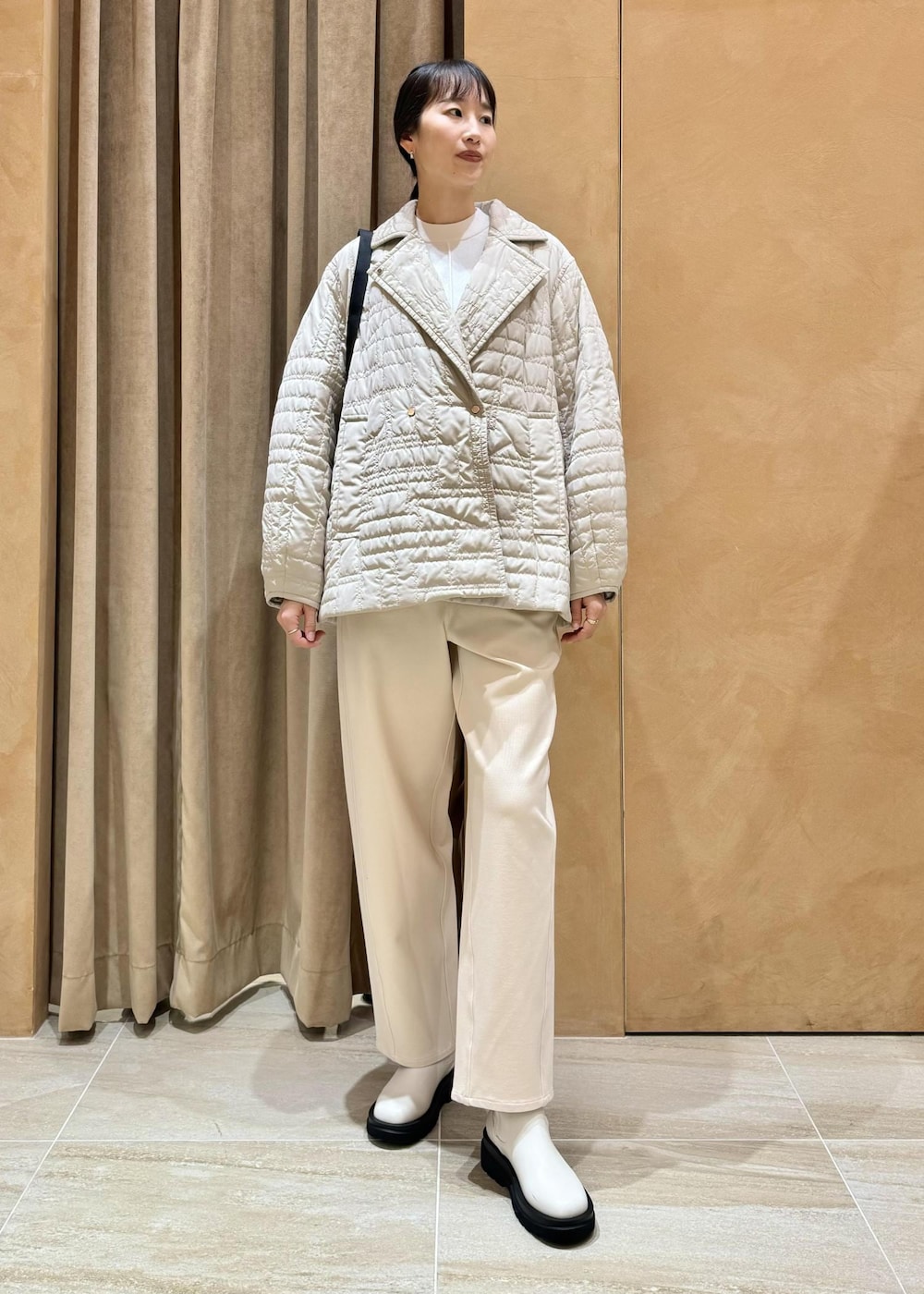 ホワイト系のブーツ、ホワイト系のその他パンツ、ベージュ系のブルゾンを着用したレディースの冬コーディネートの2枚目の写真