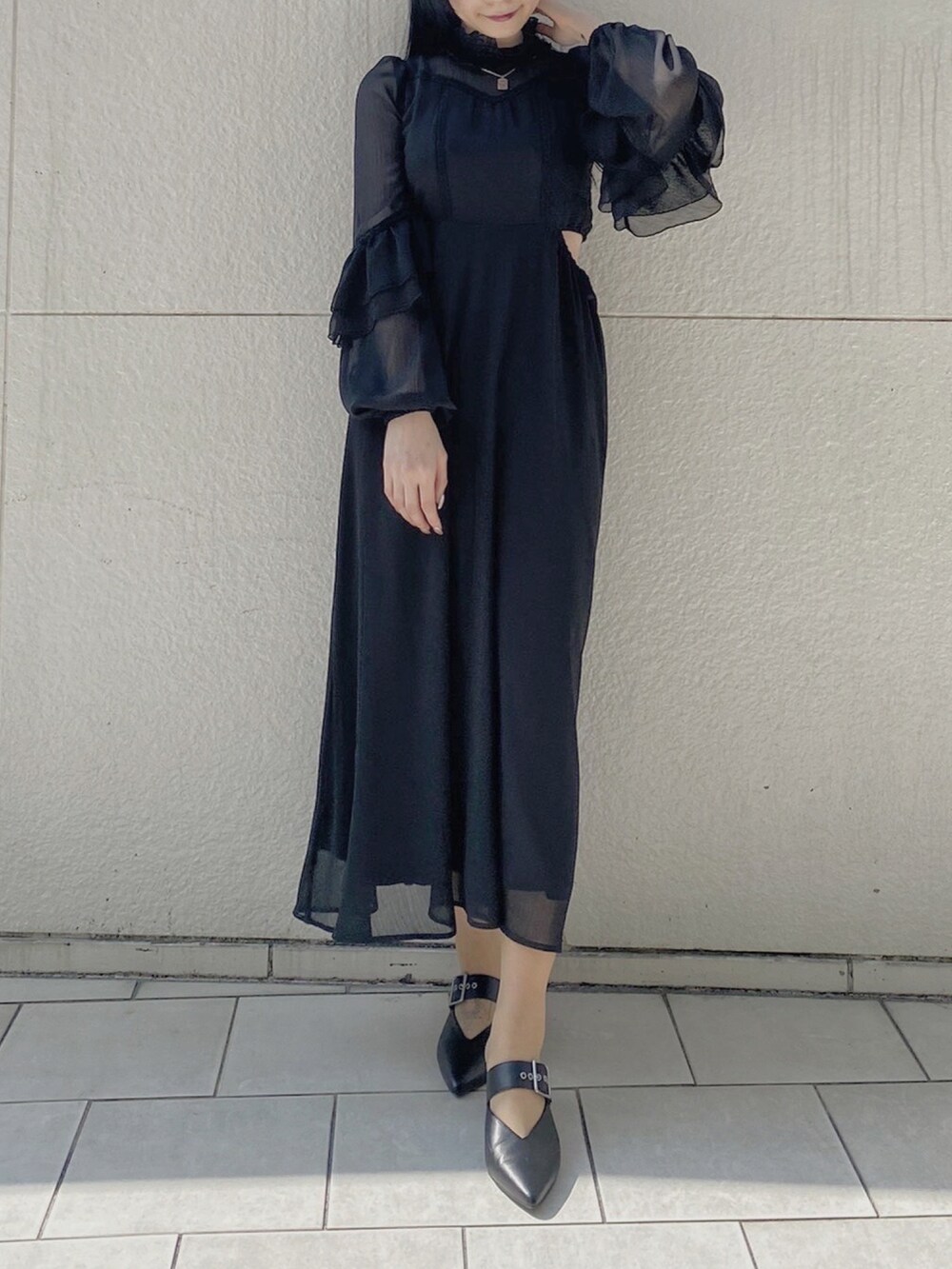 ブラック系のパンプス、ブラック系のワンピース、シルバー系のネックレスを着用したレディースの春コーディネートの2枚目の写真