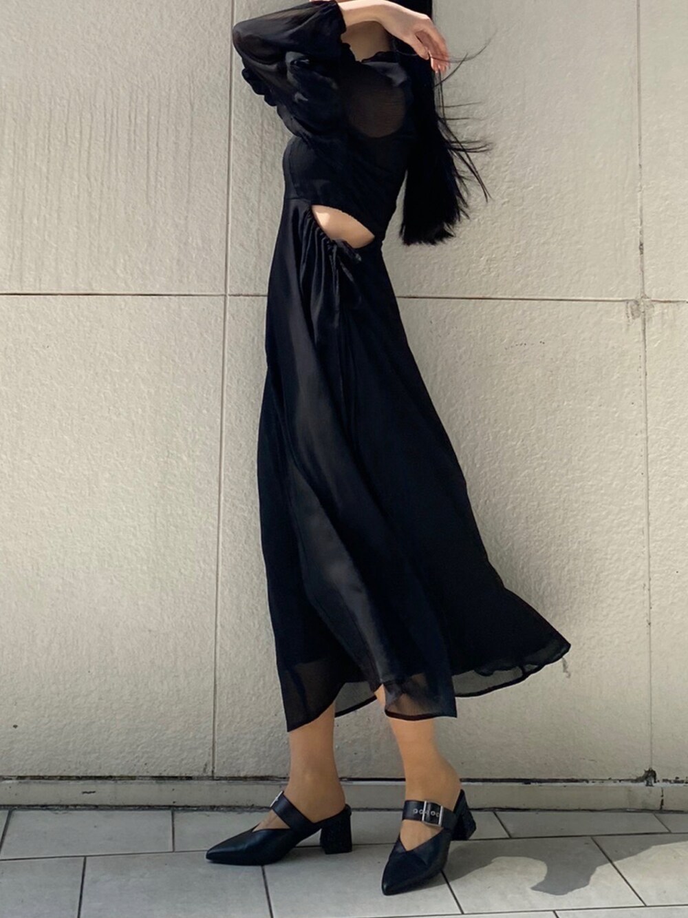 ブラック系のパンプス、ブラック系のワンピース、シルバー系のネックレスを着用したレディースの春コーディネートの3枚目の写真