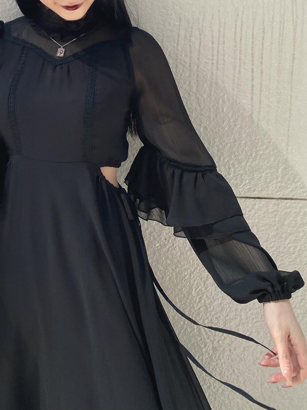 ブラック系のパンプス、ブラック系のワンピース、シルバー系のネックレスを着用したレディースの春コーディネートの5枚目の写真