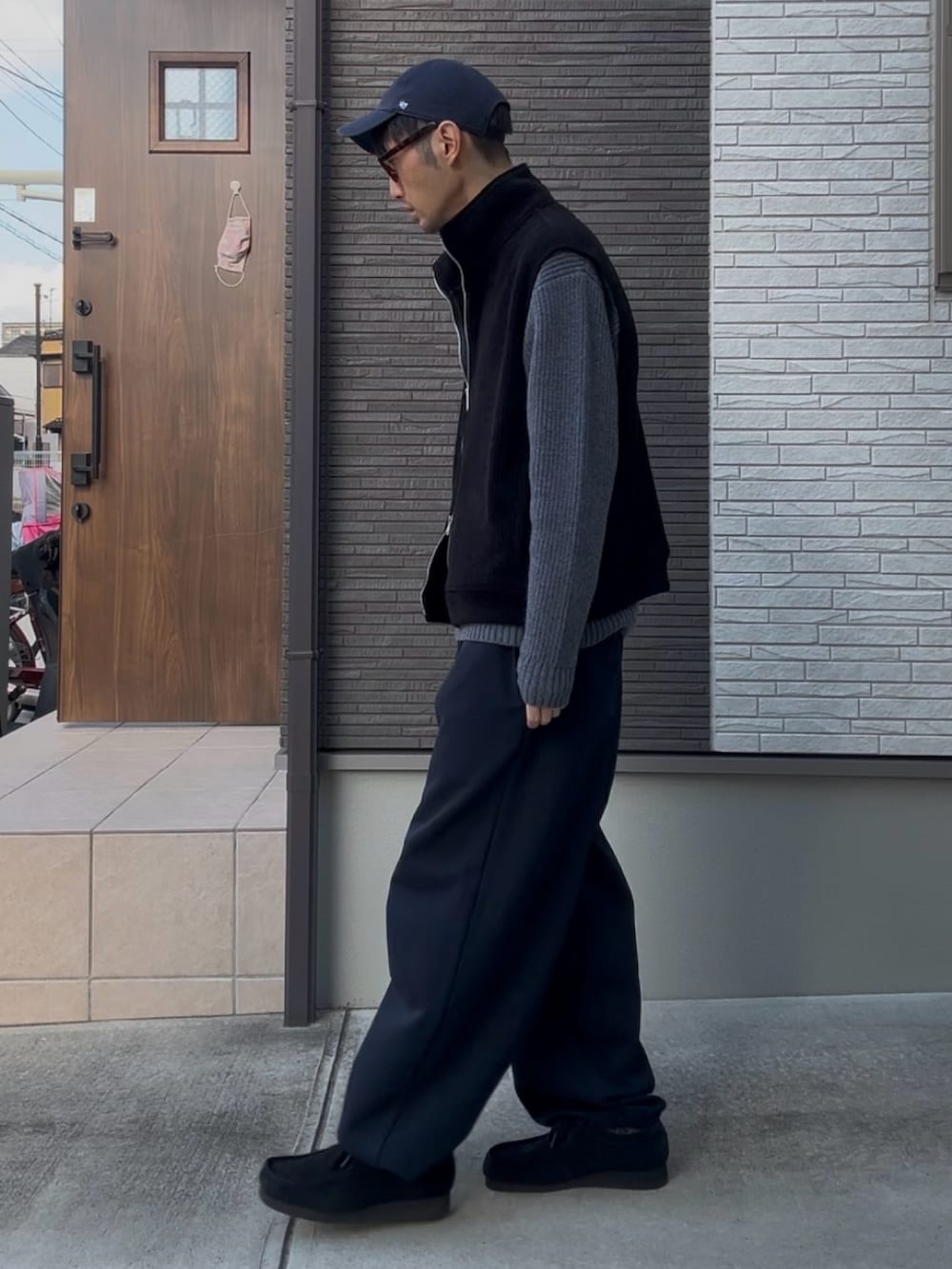 グレー系のニット/セーター、ブルー系のスウェットパンツ、ブラック系のモカシン/デッキシューズを着用したメンズの冬コーディネートの2枚目の写真