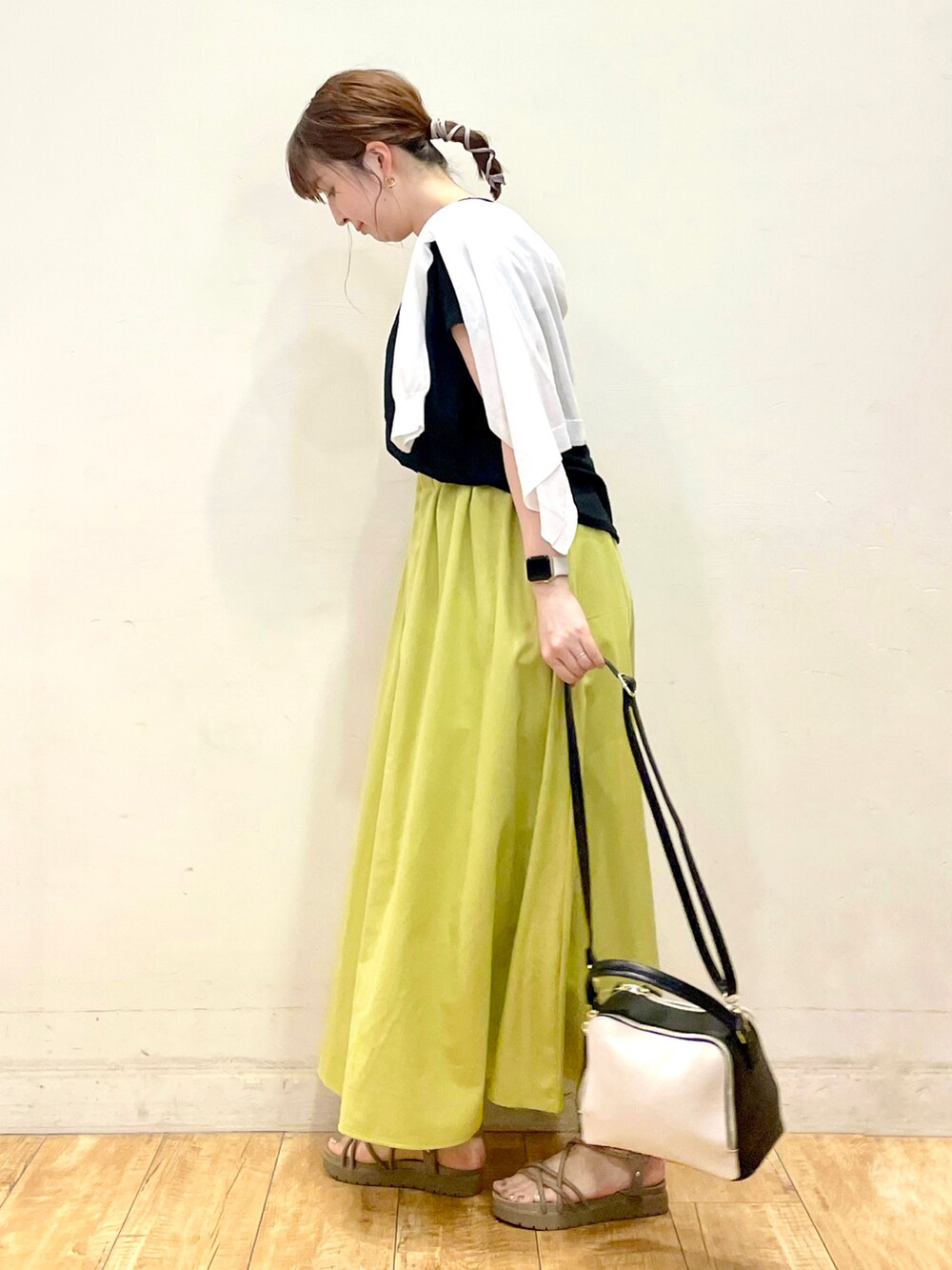 ブラック系のTシャツ/カットソー、ホワイト系のカーディガン/ボレロ、グリーン系のスカートを着用したレディースの夏コーディネートの2枚目の写真