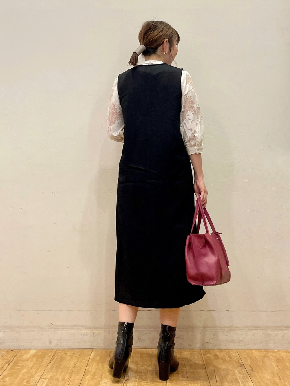 ホワイト系のTシャツ/カットソー、ブラック系のスカート、ブラック系のブーツを着用したレディースの秋コーディネートの3枚目の写真