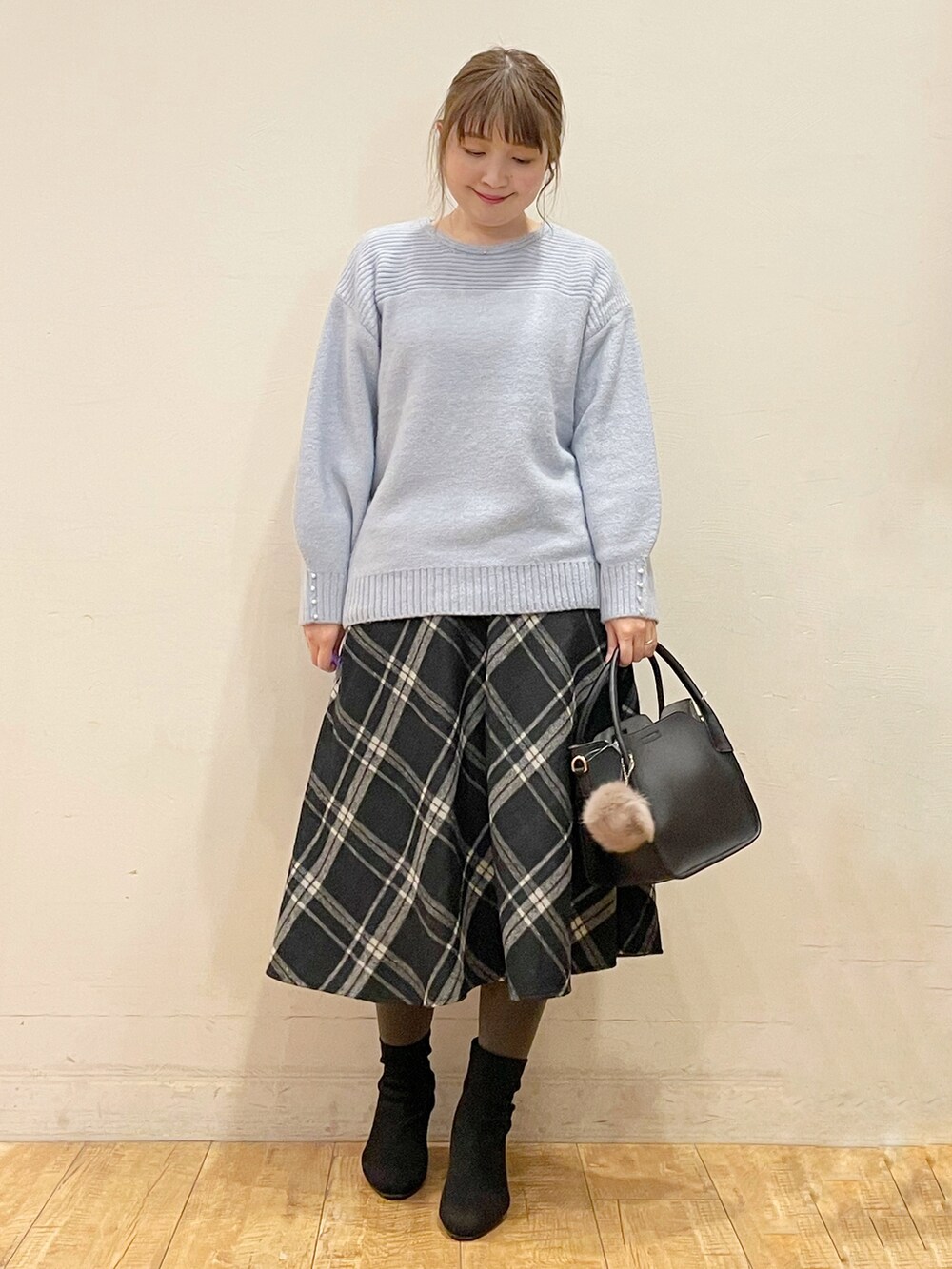 ベージュ系のダウンジャケット/コート、ブルー系のニット/セーター、ブラック系のスカートを着用したレディースの冬コーディネートの3枚目の写真