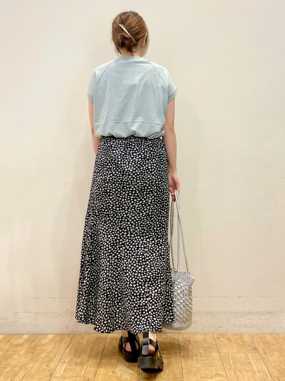 グリーン系のTシャツ/カットソー、ブラック系のスカート、シルバー系のトートバッグを着用したレディースの夏コーディネートの3枚目の写真