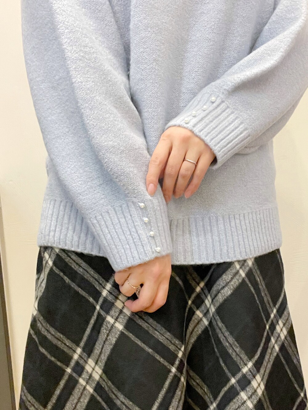 ベージュ系のダウンジャケット/コート、ブルー系のニット/セーター、ブラック系のスカートを着用したレディースの冬コーディネートの5枚目の写真