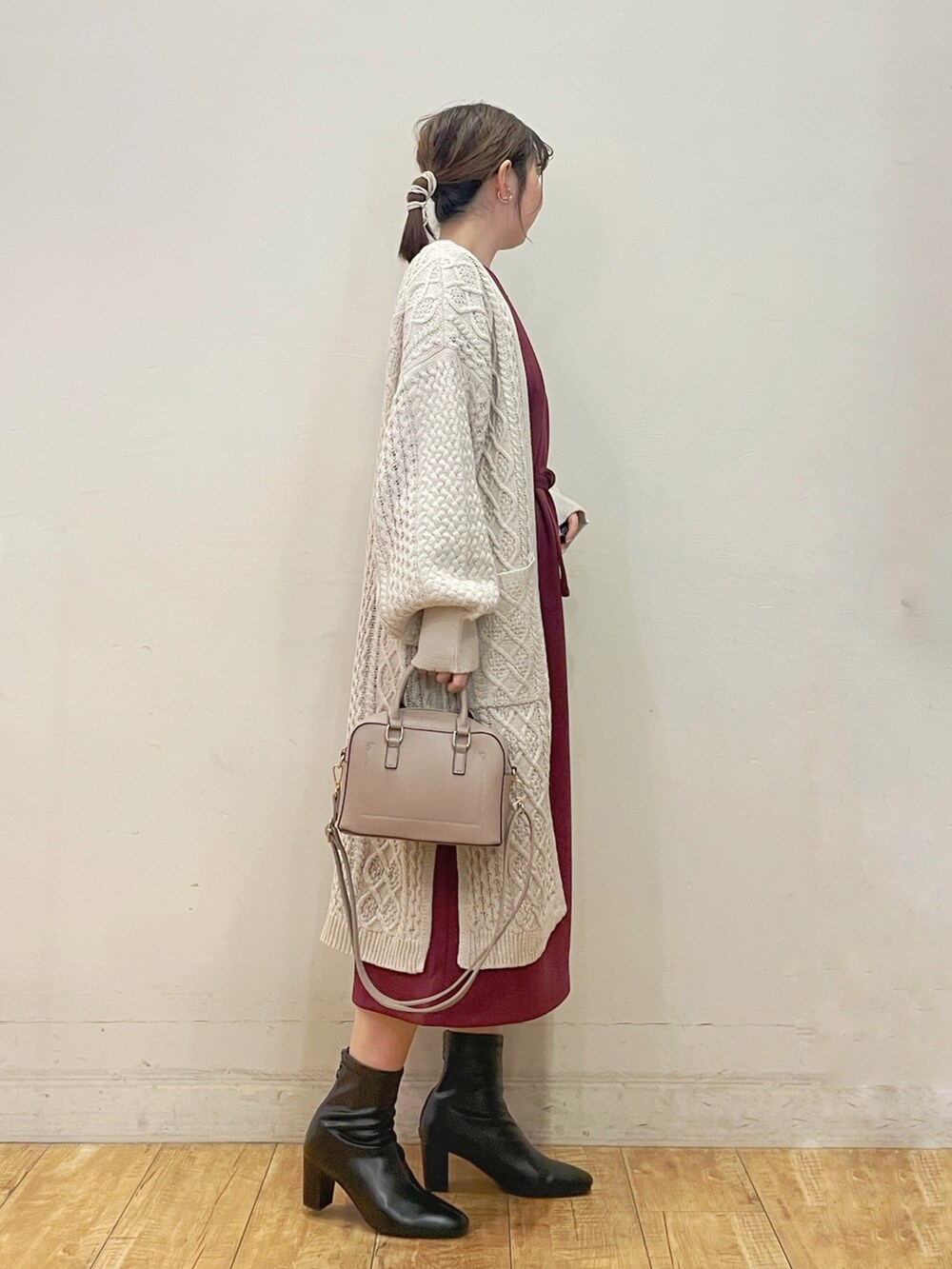 ベージュ系のカーディガン/ボレロ、レッド系のワンピース、グレー系のショルダーバッグを着用したレディースの秋コーディネートの2枚目の写真