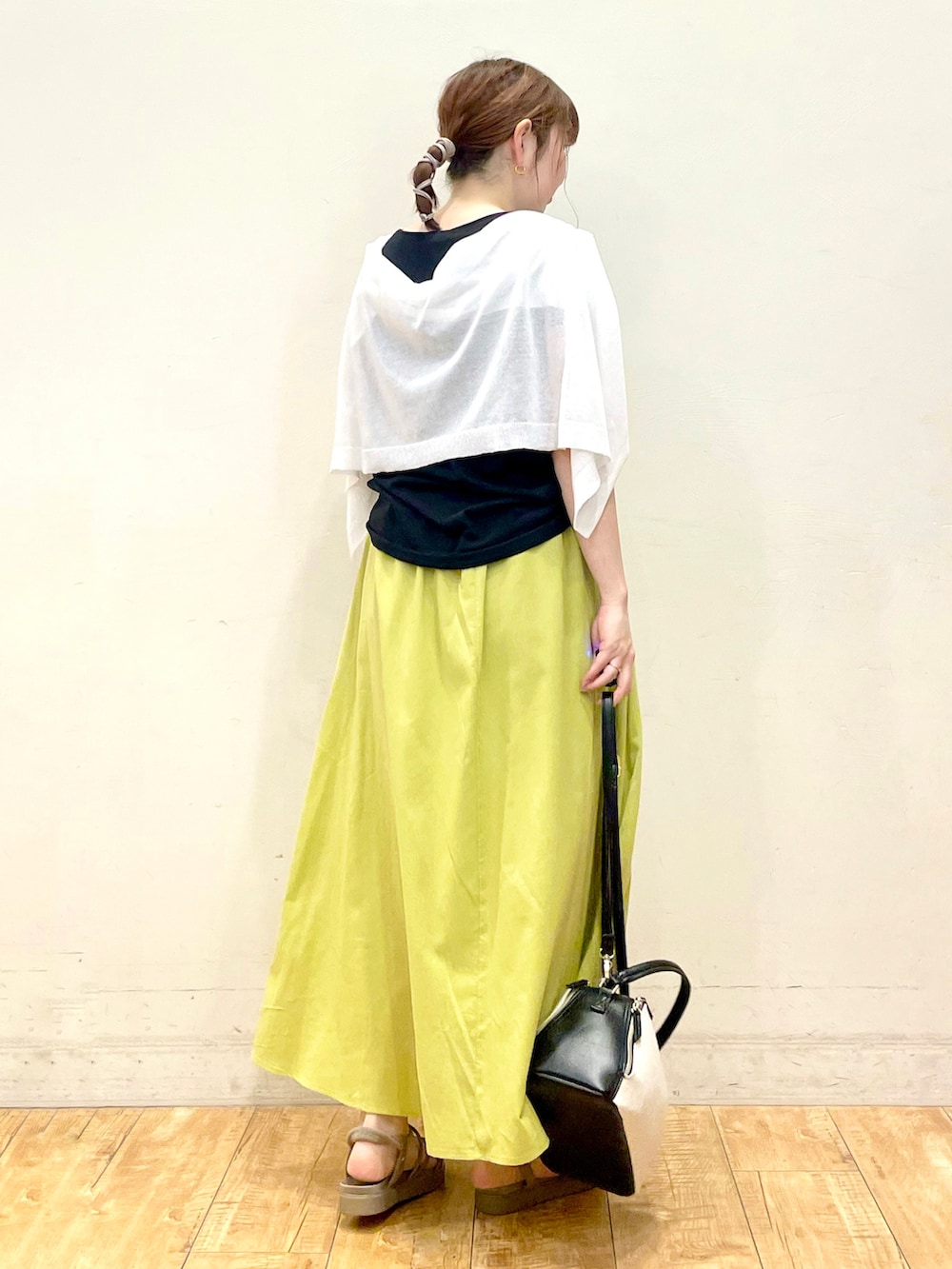 ブラック系のTシャツ/カットソー、ホワイト系のカーディガン/ボレロ、グリーン系のスカートを着用したレディースの夏コーディネートの3枚目の写真