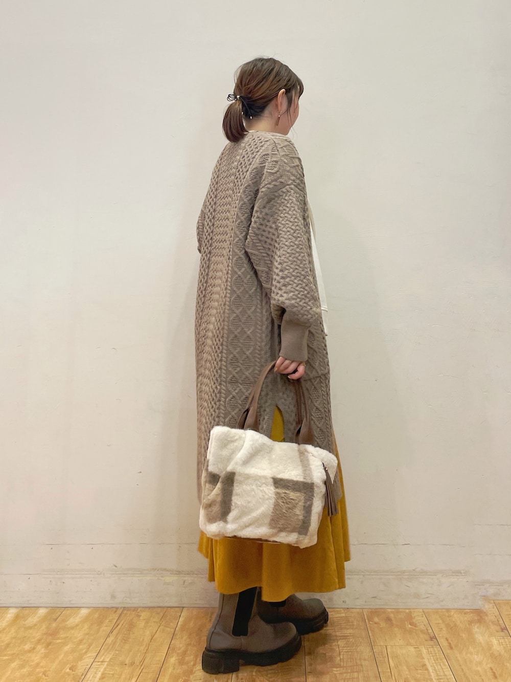 ベージュ系のカーディガン/ボレロ、ホワイト系のTシャツ/カットソー、イエロー系のスカートを着用したレディースの秋コーディネートの2枚目の写真