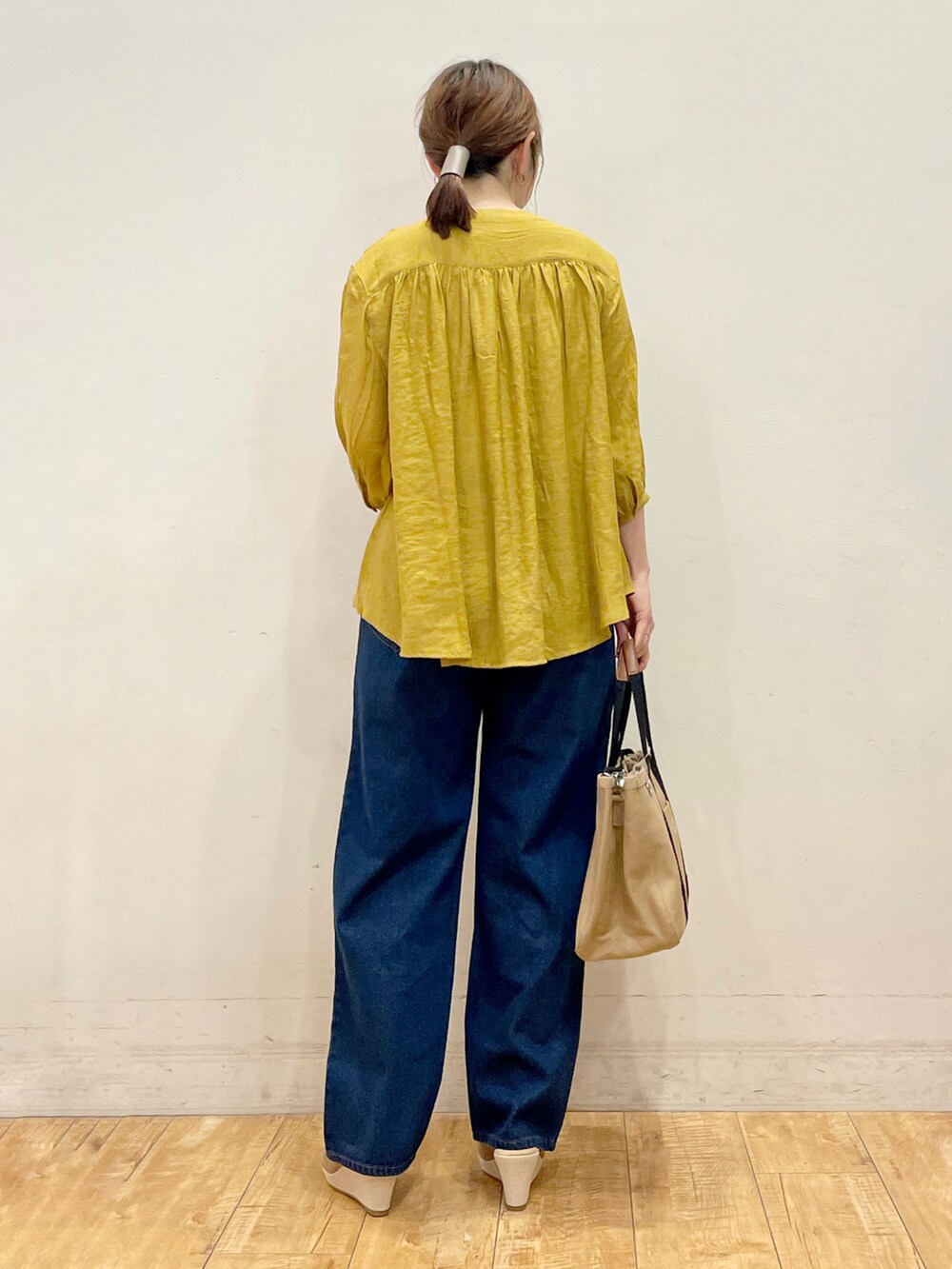 イエロー系のシャツ/ブラウス、ブルー系のデニムパンツ、ブラウン系のトートバッグを着用したレディースの夏コーディネートの4枚目の写真