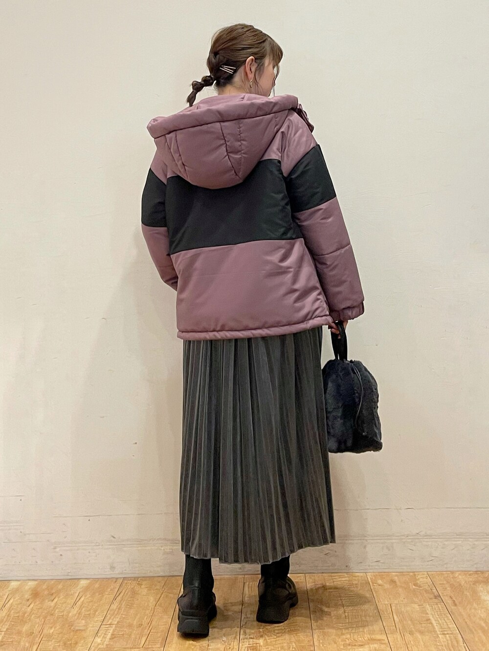 ピンク系のブルゾン、ブラック系のニット/セーター、グレー系のスカートを着用したレディースの冬コーディネートの2枚目の写真