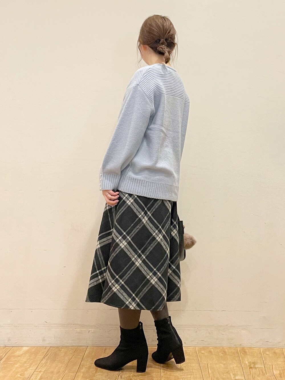 ベージュ系のダウンジャケット/コート、ブルー系のニット/セーター、ブラック系のスカートを着用したレディースの冬コーディネートの4枚目の写真